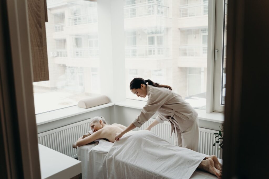 Woman massaging an older woman