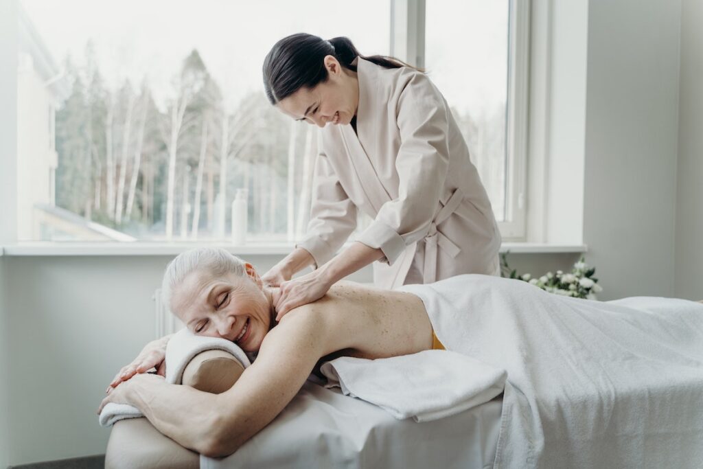 Woman massaging older client
