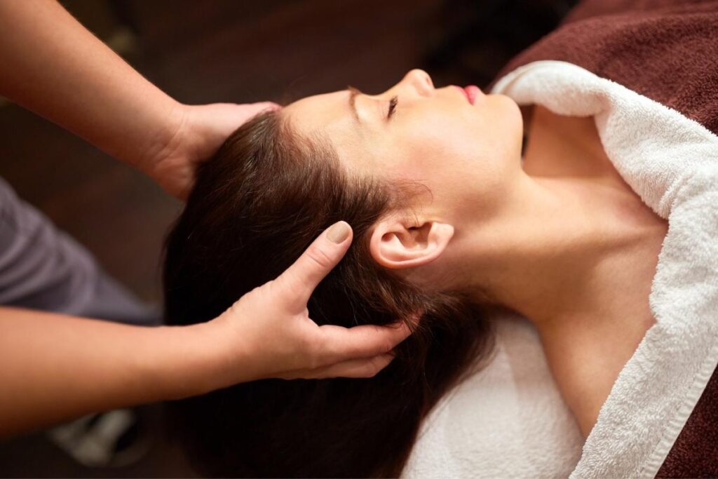 Woman getting a head massage during Urutan Malaysia